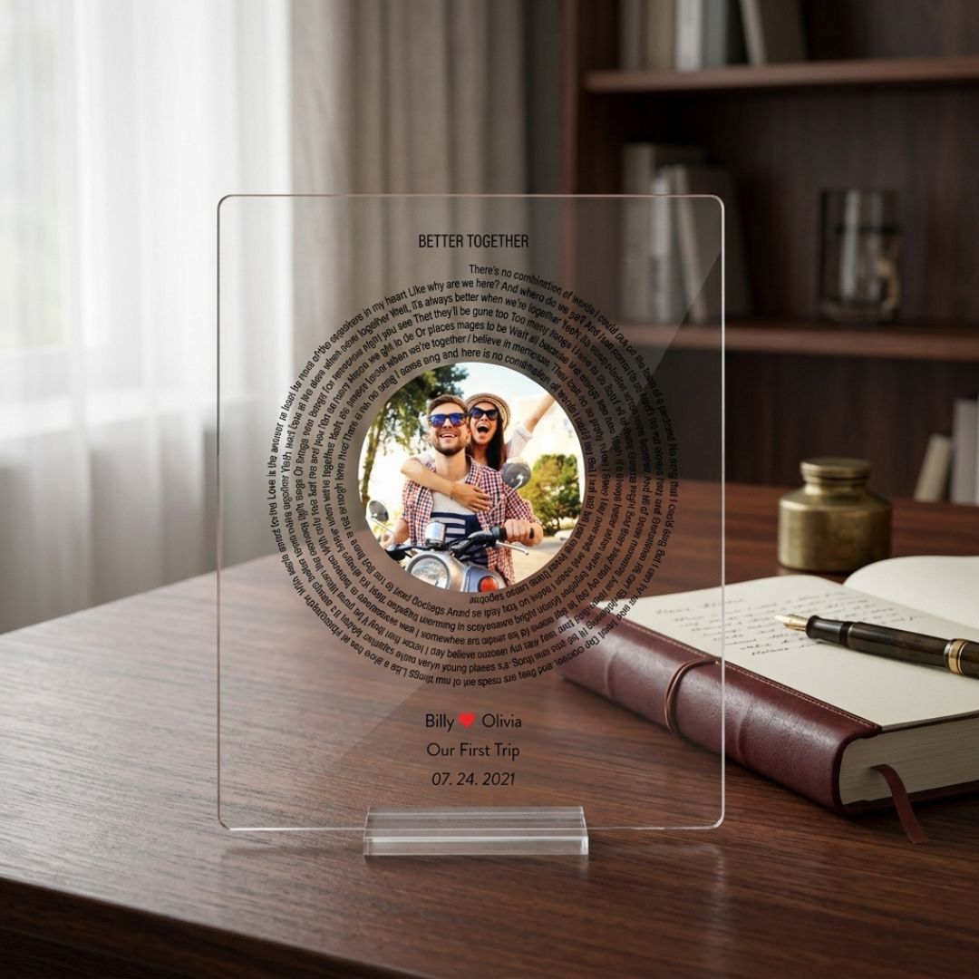 Clear acrylic plaque personalized with sample photo, song lyrics in circular text, and custom details "Billy ❤ Olivia, Our First Trip, 07.24.2021" displayed on wooden desk