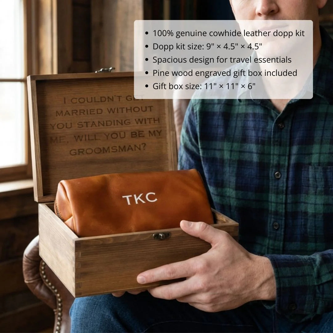 Man holding open pine wood gift box containing cognac leather dopp kit monogrammed with sample initials "TKC" and engraved wooden box lid with groomsman proposal text