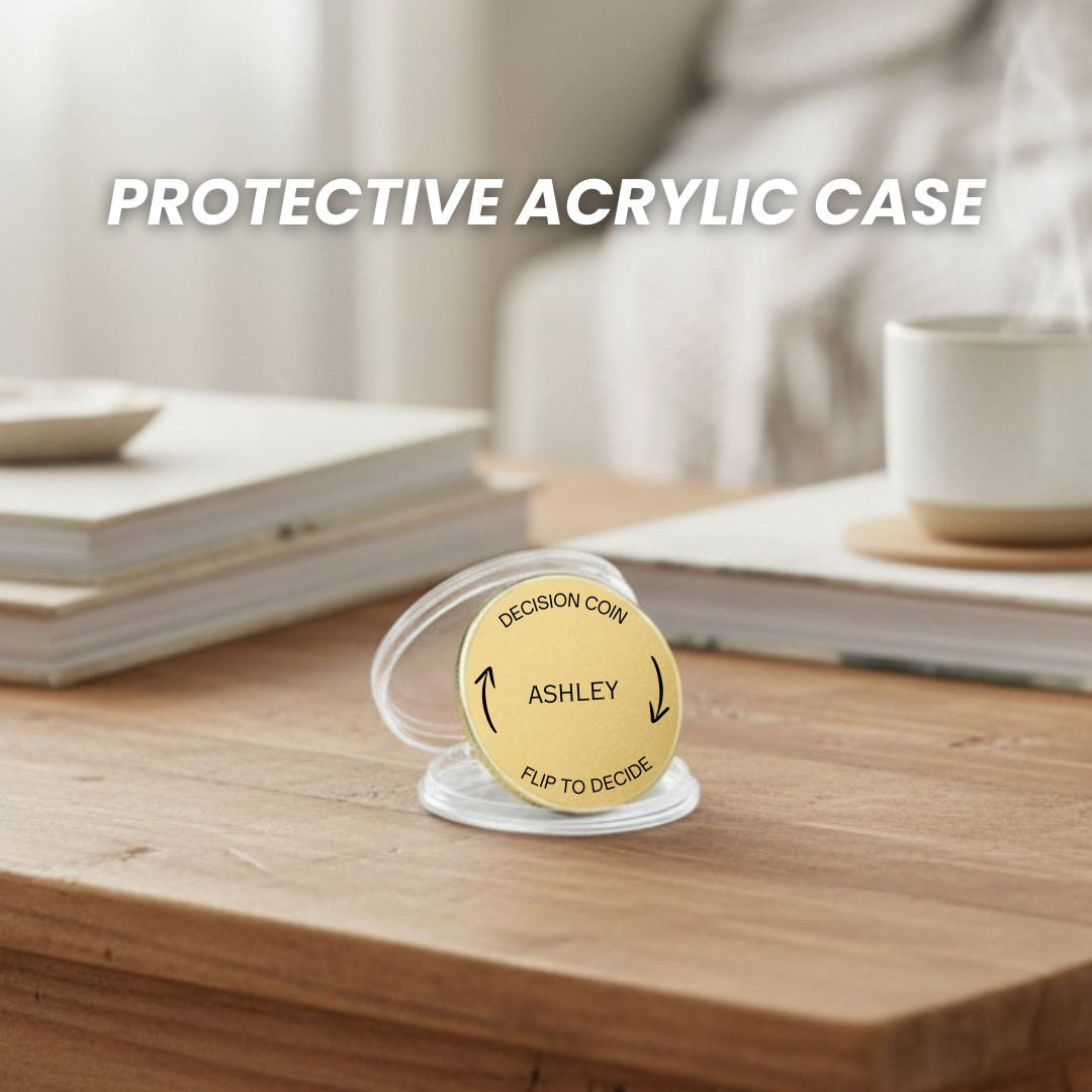 Brass decision coin with sample personalization reading "ASHLEY" and "FLIP TO DECIDE" text, displayed in clear acrylic protective case on wooden desk