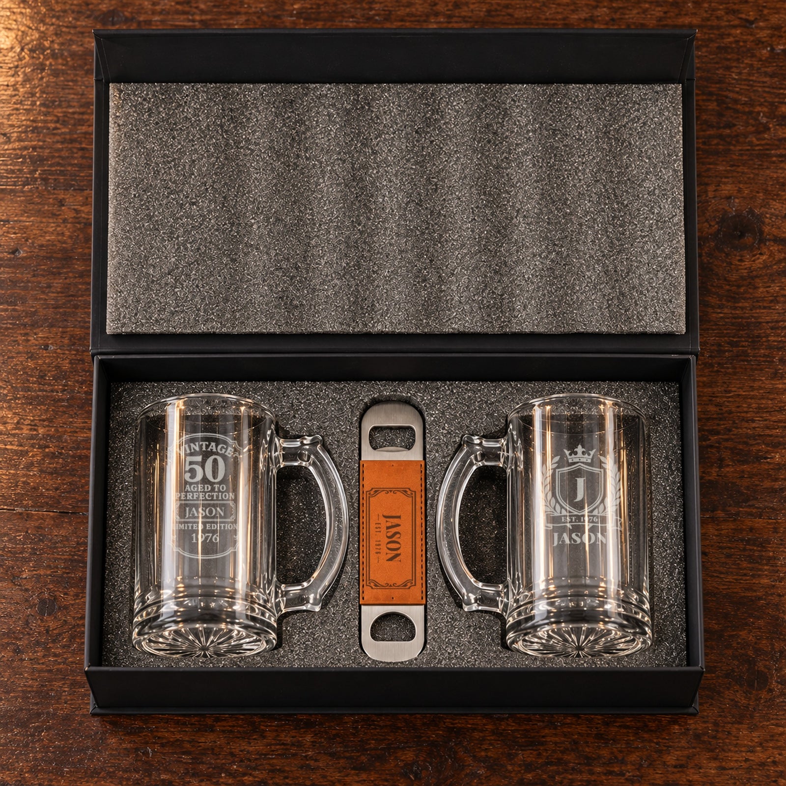 The 50th birthday beer gift set open in its foam-lined box: a Vintage 50 mug and a crest mug for Jason, with his engraved bottle opener