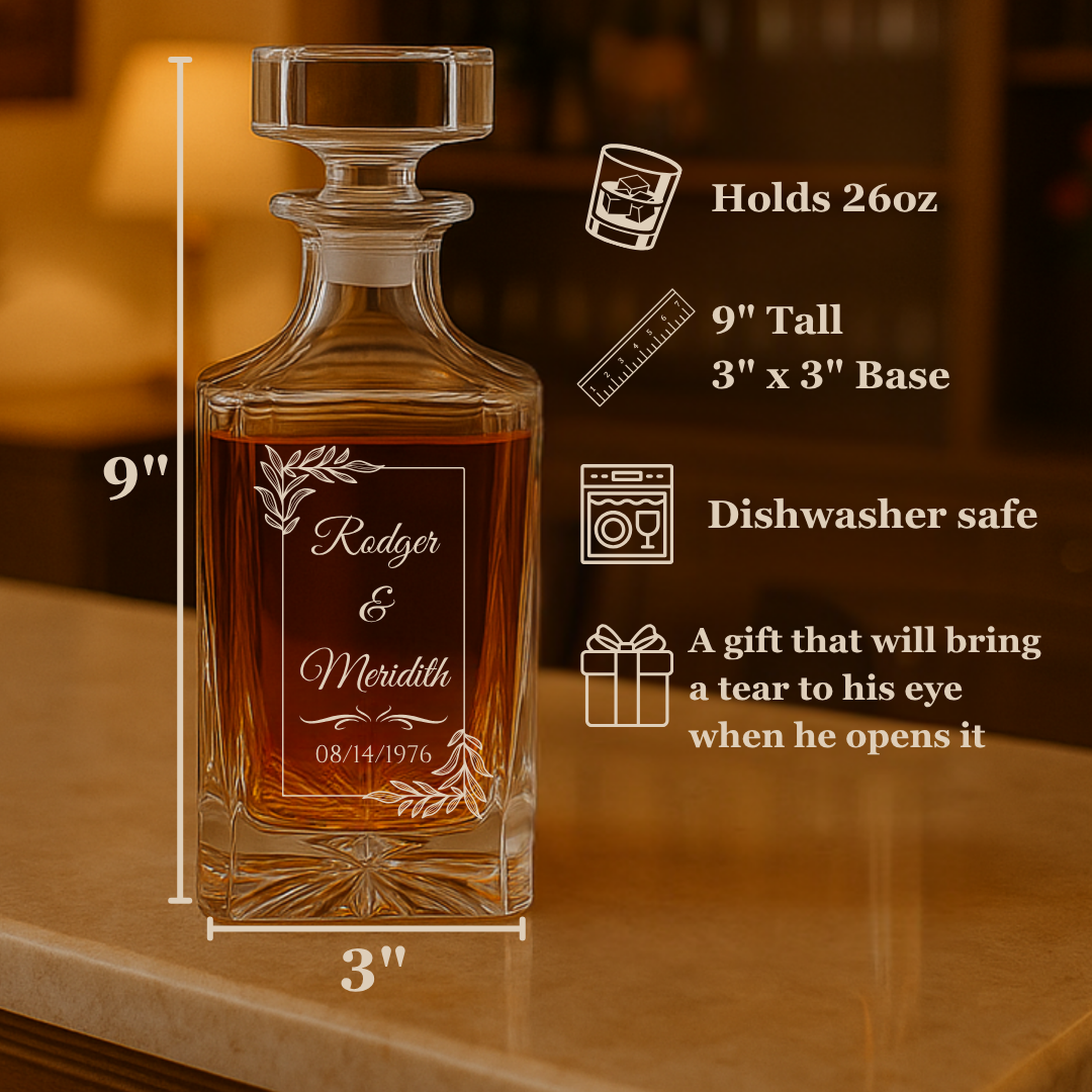 Crystal decanter with sample engraving reading "Rodger & Meridith 08/14/1976" and decorative leaf motifs, displayed filled with amber liquid on wooden surface