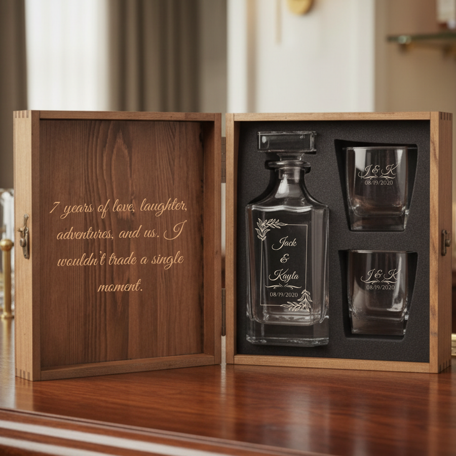 Personalized 7 year anniversary whiskey decanter set shown open, with the couple's private message engraved inside the wooden box lid beside the decanter and two glasses.