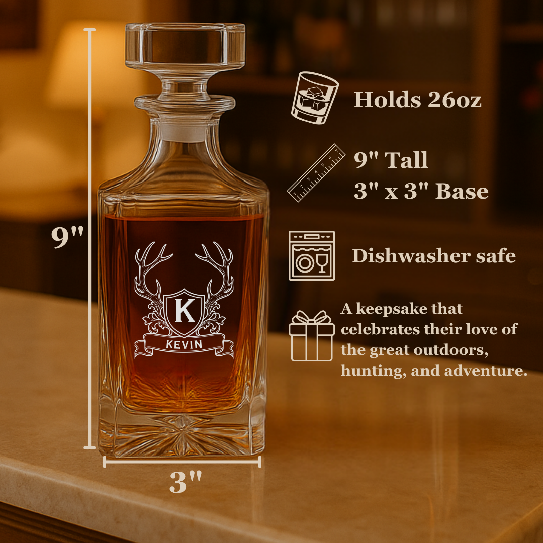 Bourbon decanter engraved with an antler crest monogram, labeled 9 inches tall with a 3 by 3 inch base, holding 26 oz and dishwasher safe