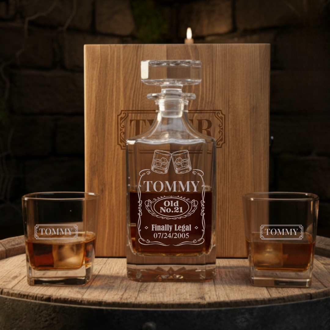 Wooden decanter set with personalized engraving reading "TOMMY Old No. 21 Finally Legal 07/24/2005" displayed with two matching glasses and wooden presentation box