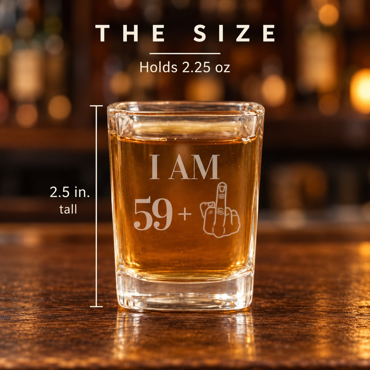 Size of the funny 60th birthday shot glass: 2.5 inches tall and holds 2.25 oz, engraved I AM 59 plus a middle finger hand, shown on a wood bar.