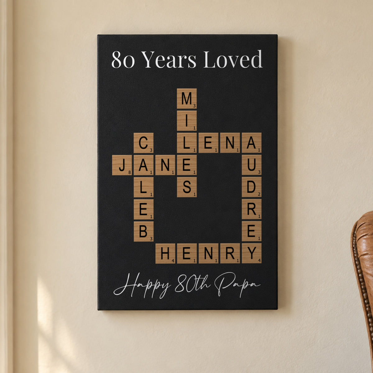 80th birthday gift for men: an 80 Years Loved crossword sign with the grandkids' names and Happy 80th Papa, hanging in a sunny reading nook