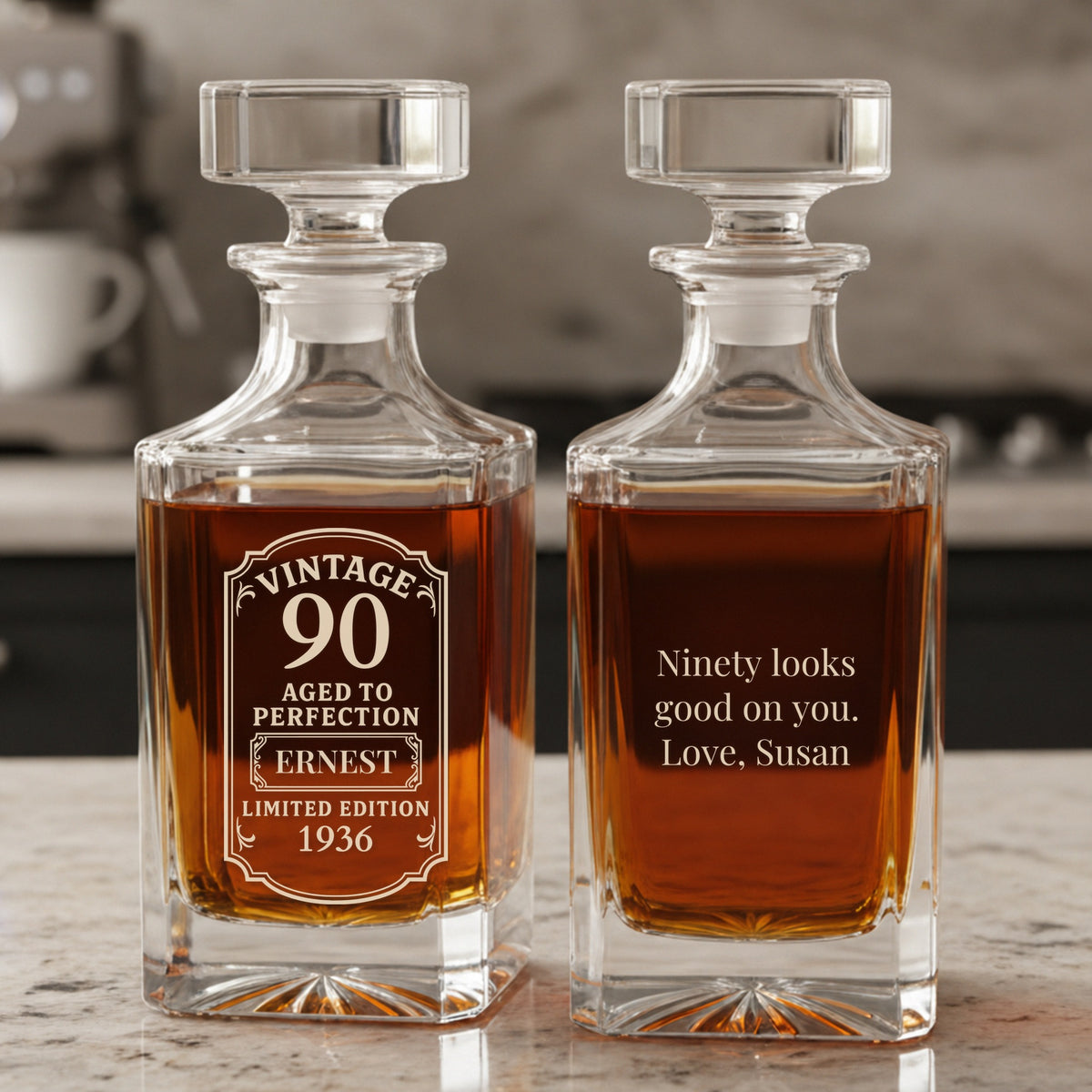 Personalized Vintage 90 decanters on a marble counter with ERNEST and 1936 on the front and a note from Susan on the back, one of our 90th birthday gifts for him