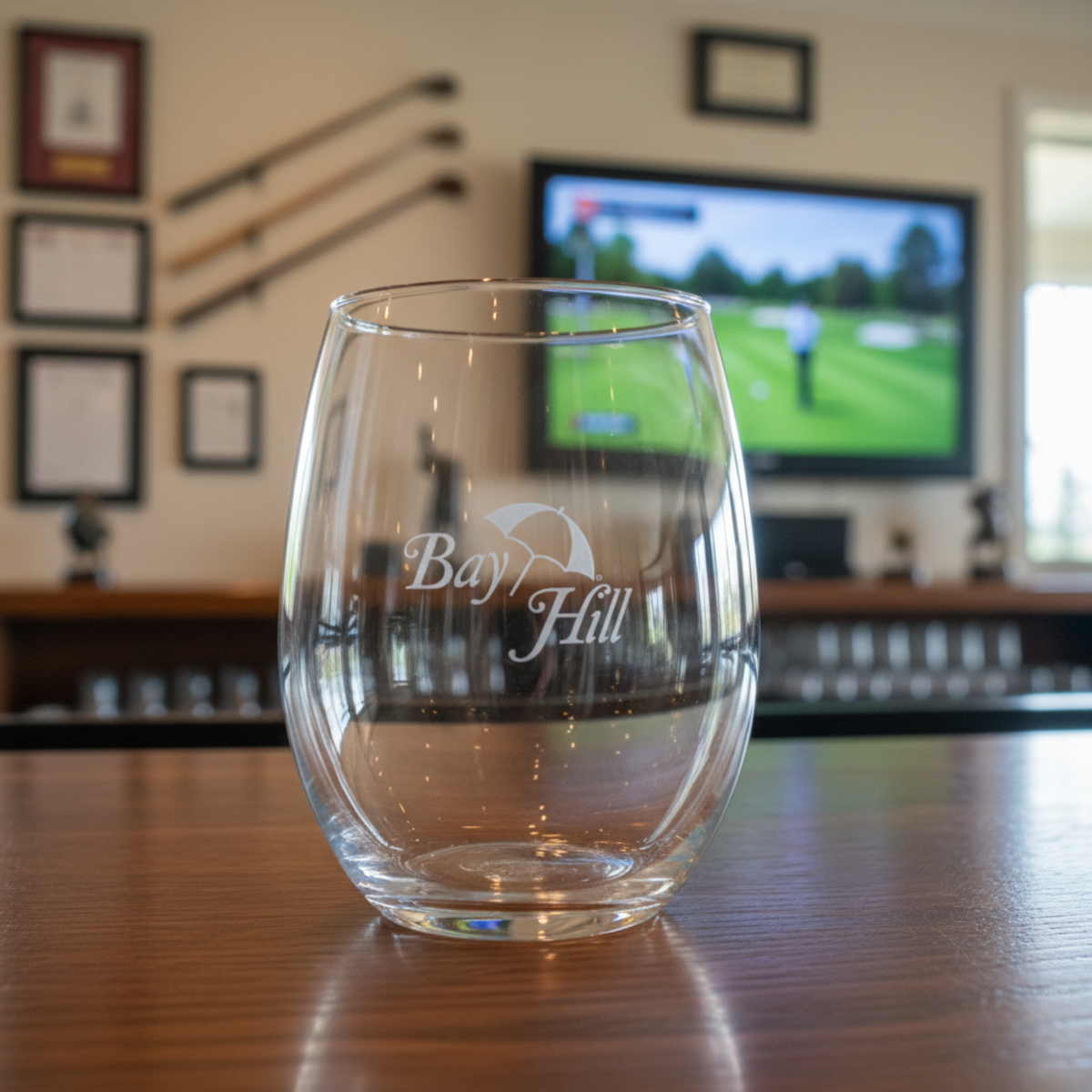 Stemless wine glass with a sample company logo laser-engraved on the front, shown on a wooden table as a custom logo corporate gift.