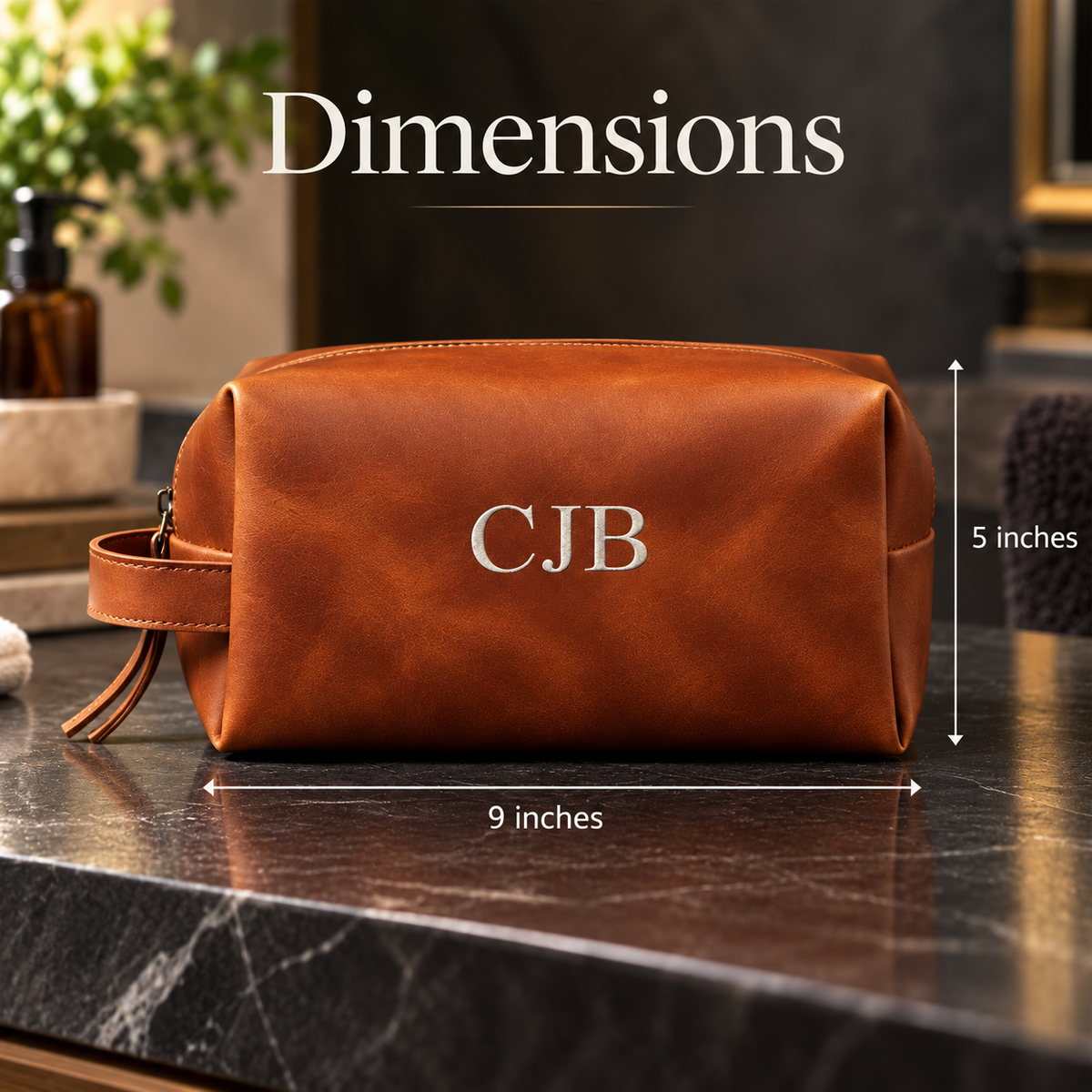 Cognac leather dopp kit with sample monogram "CJB" embroidered on front, displayed with dimensions of 9 inches width and 5 inches height
