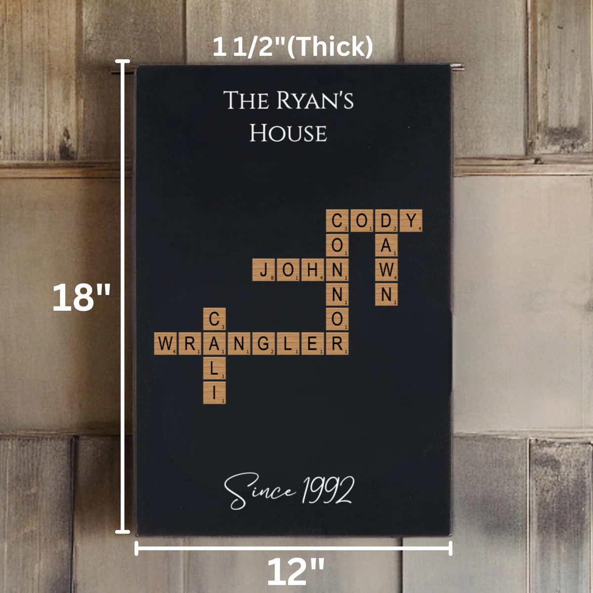 Black wall sign with sample family names arranged in crossword-style layout with wooden tile letters, showing dimensions 12" W x 18" H and "Since 1992" text