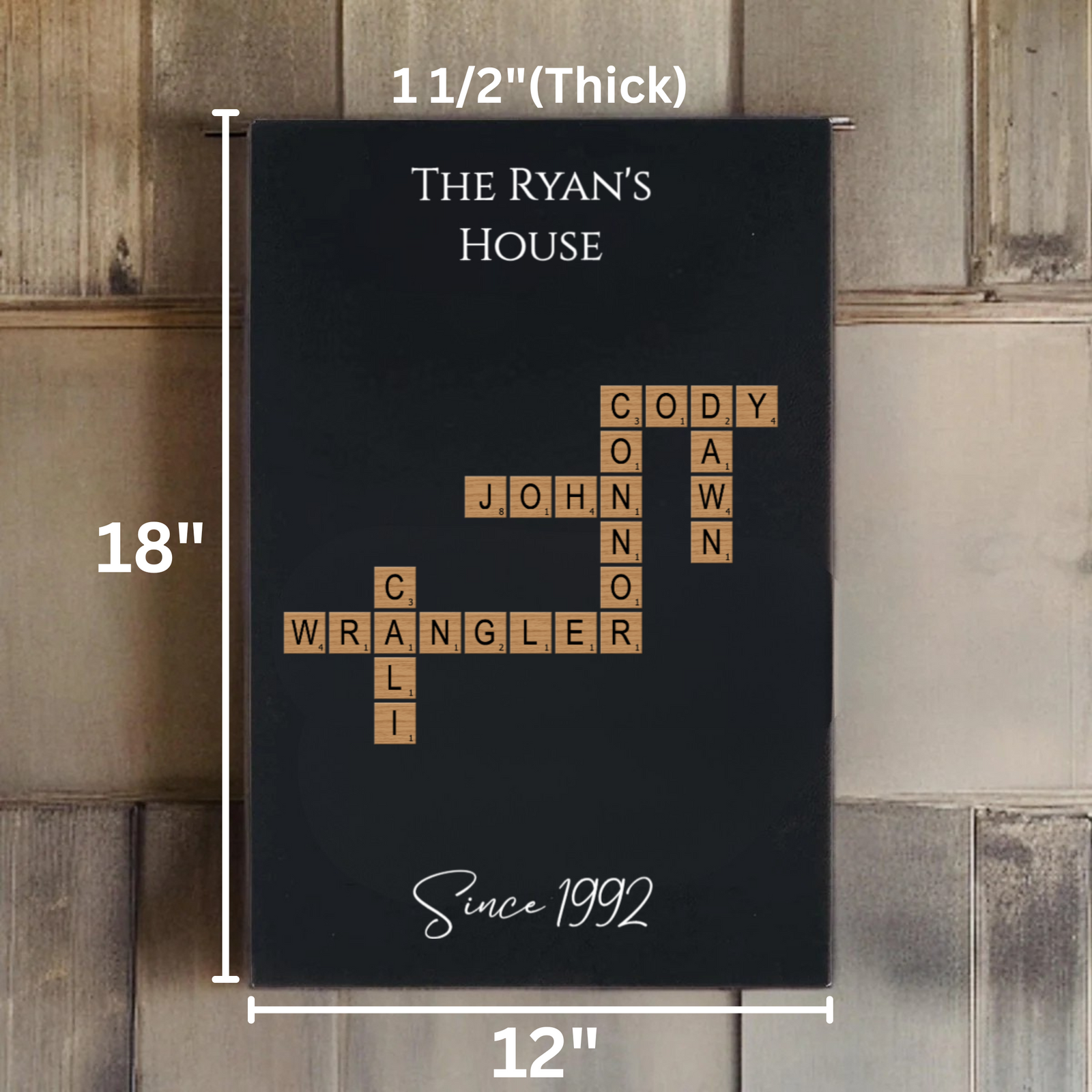 Black wall sign with sample family names arranged in crossword-style layout with wooden tile letters, showing dimensions 12" W x 18" H and "Since 1992" text