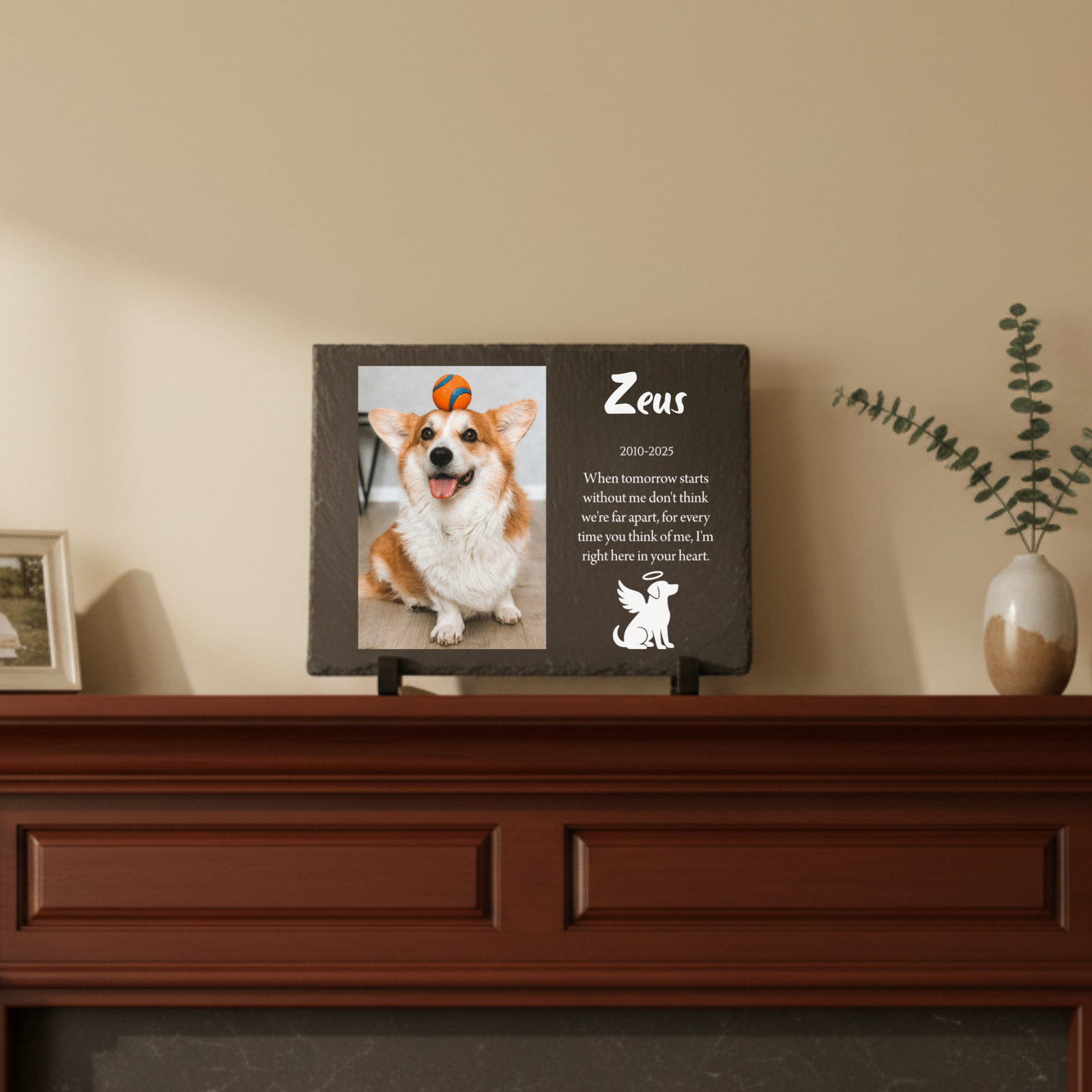 Dark slate memorial plaque displayed on mantel, personalized with dog photo, name "Zeus," dates 2010-2025, and custom message with angel dog icon