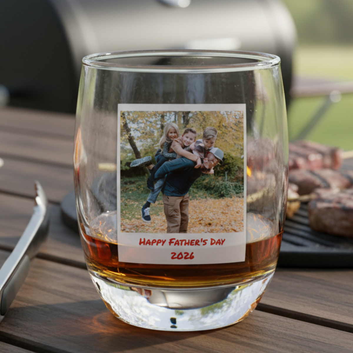 Whiskey glass with sample photo showing father and children in fall setting, personalized with "Happy Father's Day 2026" text