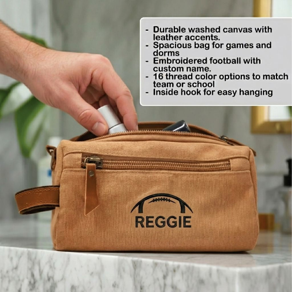 Tan washed canvas toiletry bag with leather handle, embroidered with sample football design and name "REGGIE" in black thread, hand holding open zipper