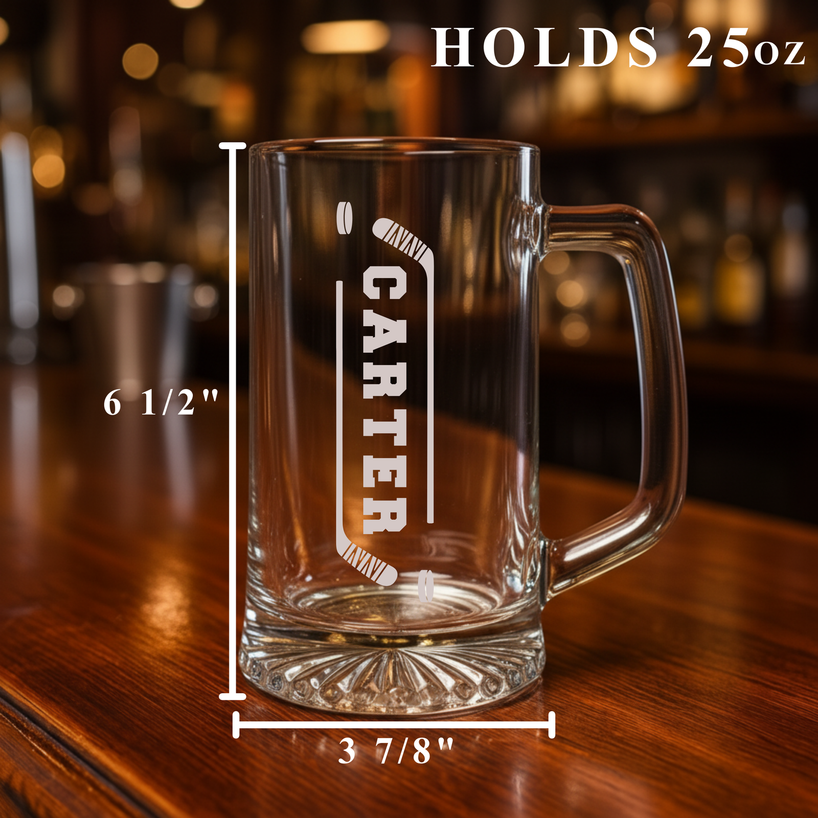 25oz beer mug with sample engraving reading "CARTER" vertically flanked by crossed hockey sticks, displayed on wooden surface with dimensions marked