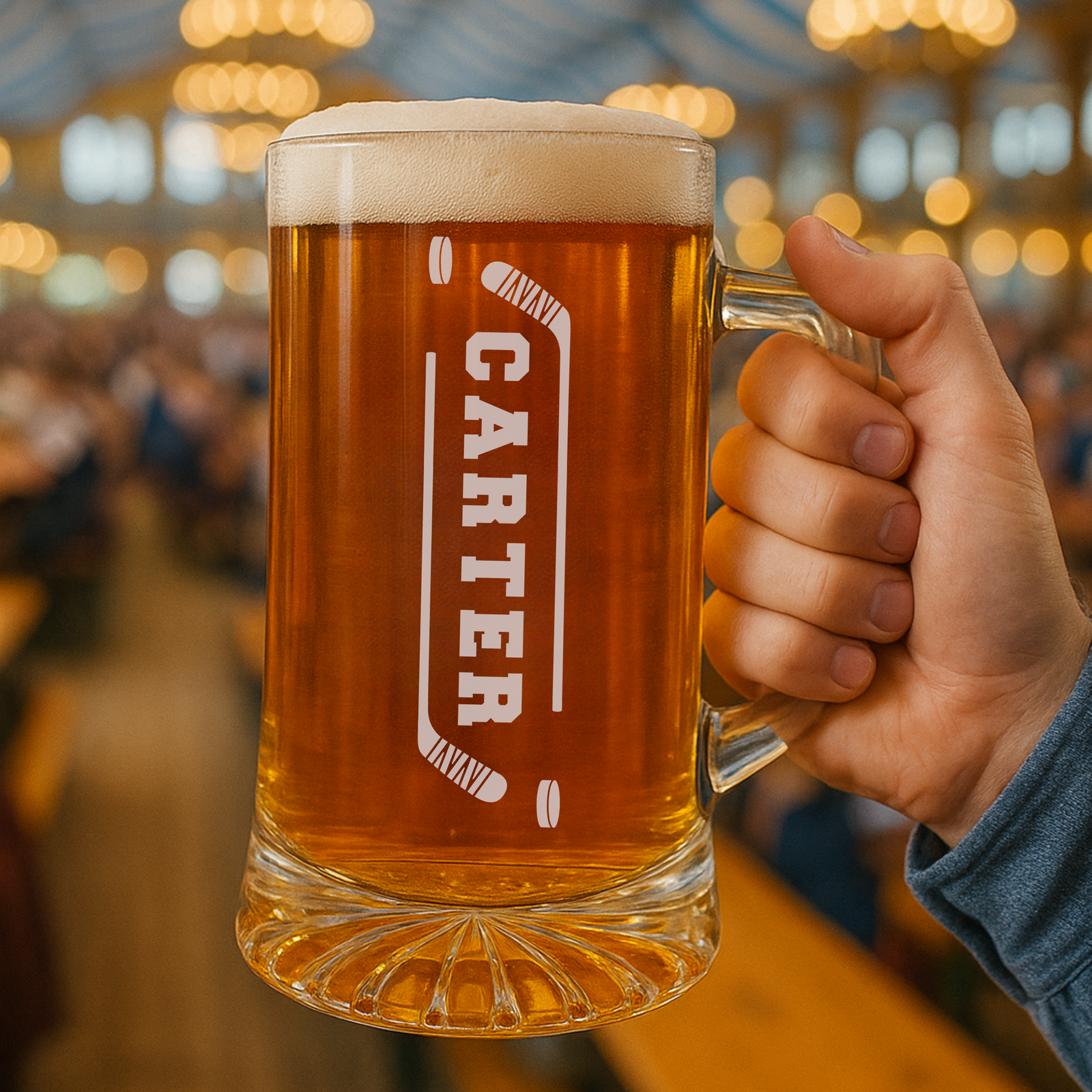 Beer mug engraved with sample name "CARTER" flanked by crossed hockey stick designs, filled with amber beer and condensation on glass