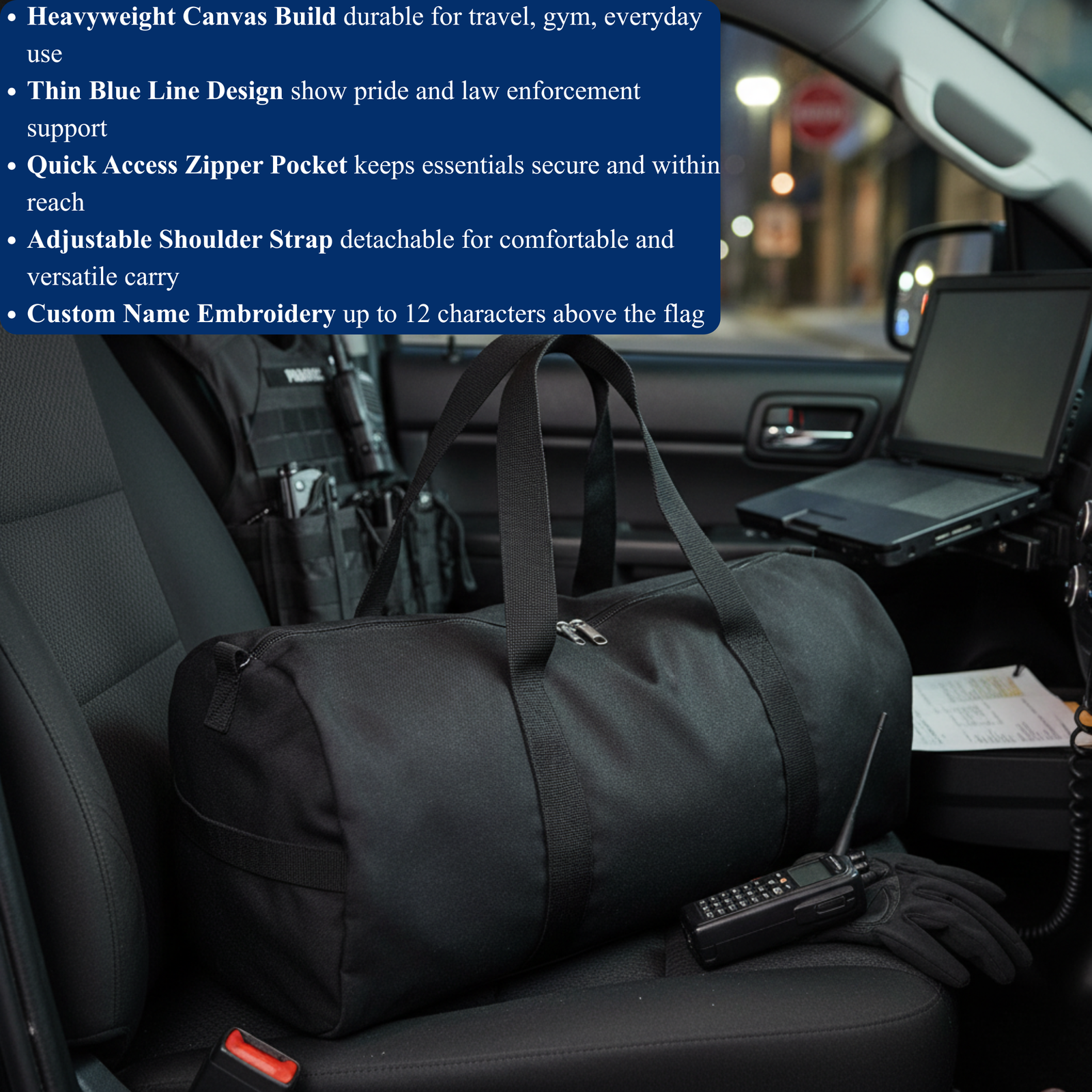 Black canvas duffle bag with dual shoulder straps placed on vehicle seat, featuring thin blue line flag design above front zipper pocket