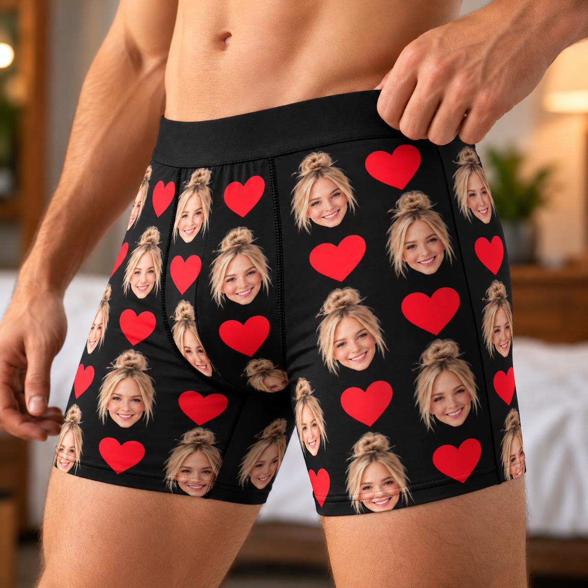 Black boxer briefs printed all over with a smiling woman's face in with blonde hair and red hearts, worn by a man in a bedroom