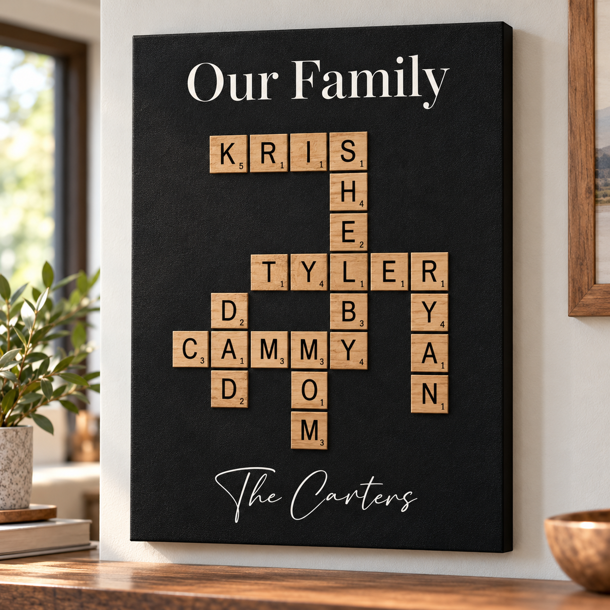 Family crossword wall art on a living room wall, Our Family title over wood-tone letter tiles spelling Kris, Shelby, Tyler, Ryan, Dad, Cammy and Mom