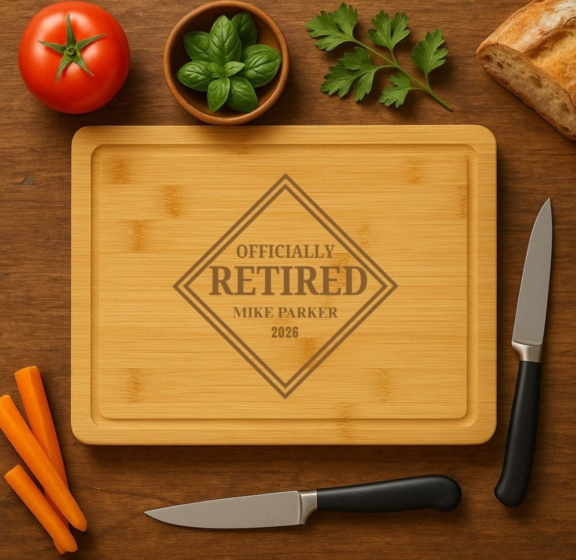 Bamboo cutting board engraved with diamond-shaped design reading "Officially Retired" with sample personalization "Mike Parker 2026", surrounded by fresh produce and kitchen knives on wooden surface