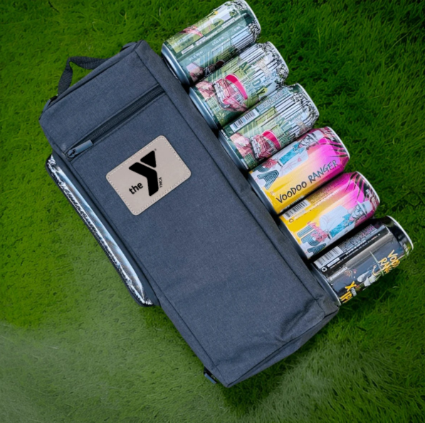 Dark blue golf cooler bag with logo displayed open, revealing multiple compartments filled with assorted beverages and canned drinks arranged vertically on green grass surface
