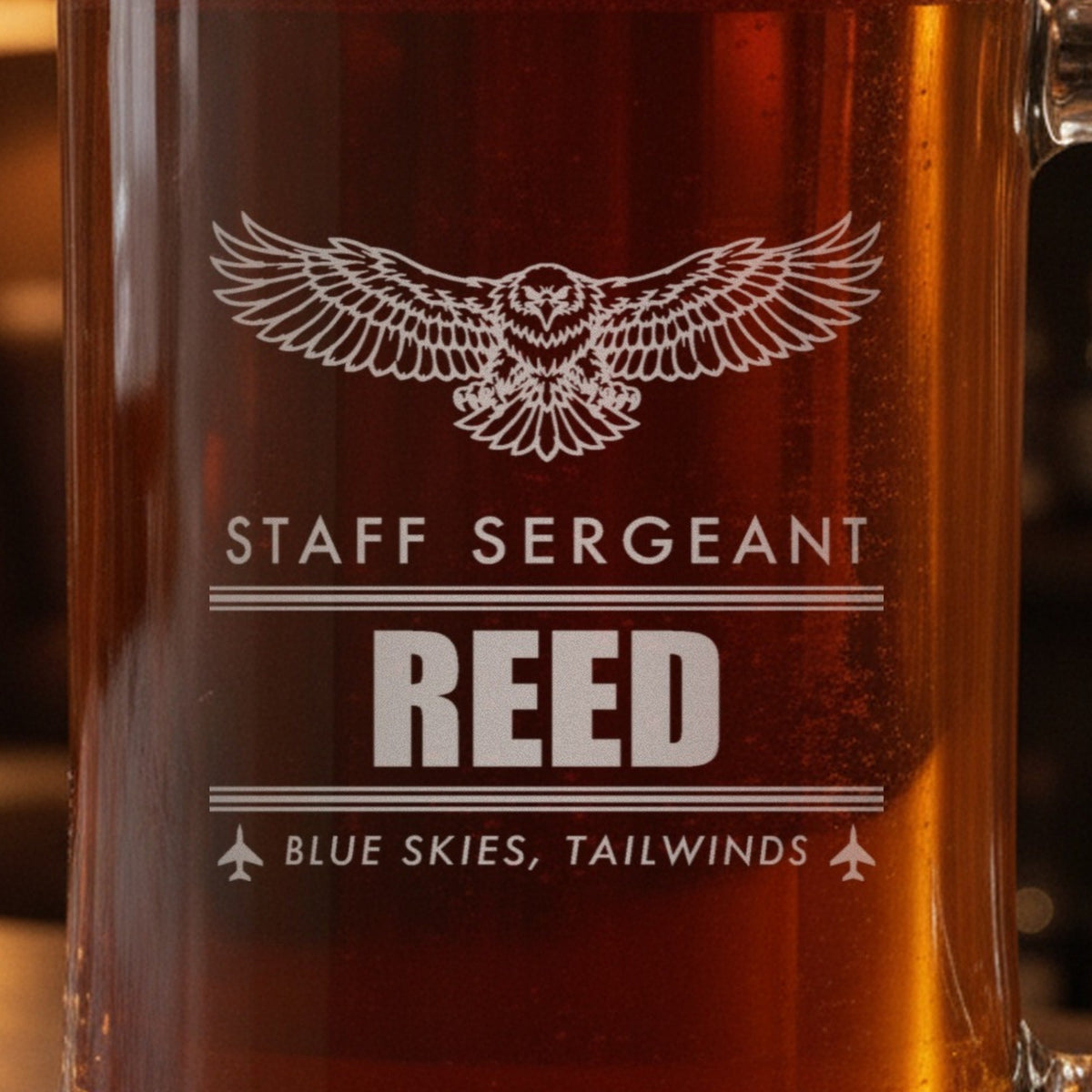 Close-up of the frosted eagle engraving on a retired Air Force gift stein: Staff Sergeant, Reed between contrail lines and Blue Skies, Tailwinds