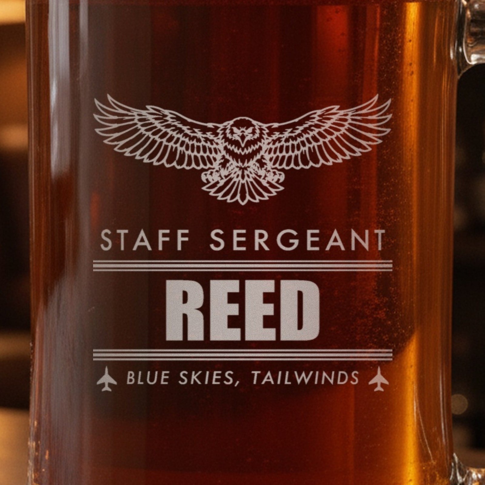 Close-up of the frosted eagle engraving on a retired Air Force gift stein: Staff Sergeant, Reed between contrail lines and Blue Skies, Tailwinds