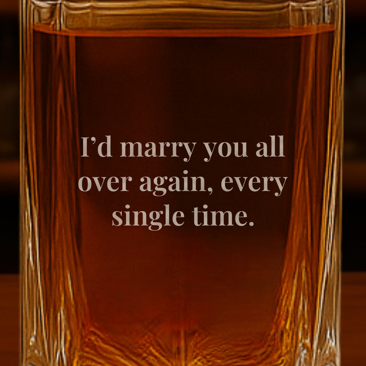 Close-up of an anniversary message engraved on the back of a whiskey decanter for husband that reads I'd marry you all over again, every single time