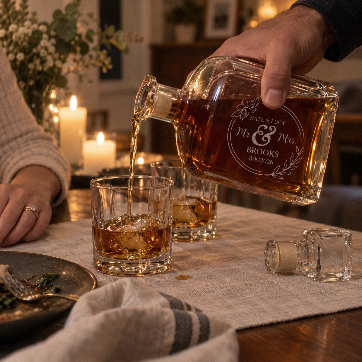 Pouring whiskey from a Mr and Mrs decanter etched NATE & LUCY BROOKS at an anniversary dinner at home, a wedding and anniversary gift
