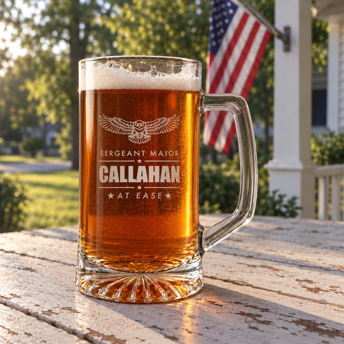 Army retirement beer stein on a front porch table with an American flag behind it, engraved with an eagle, Sergeant Major, Callahan and At Ease