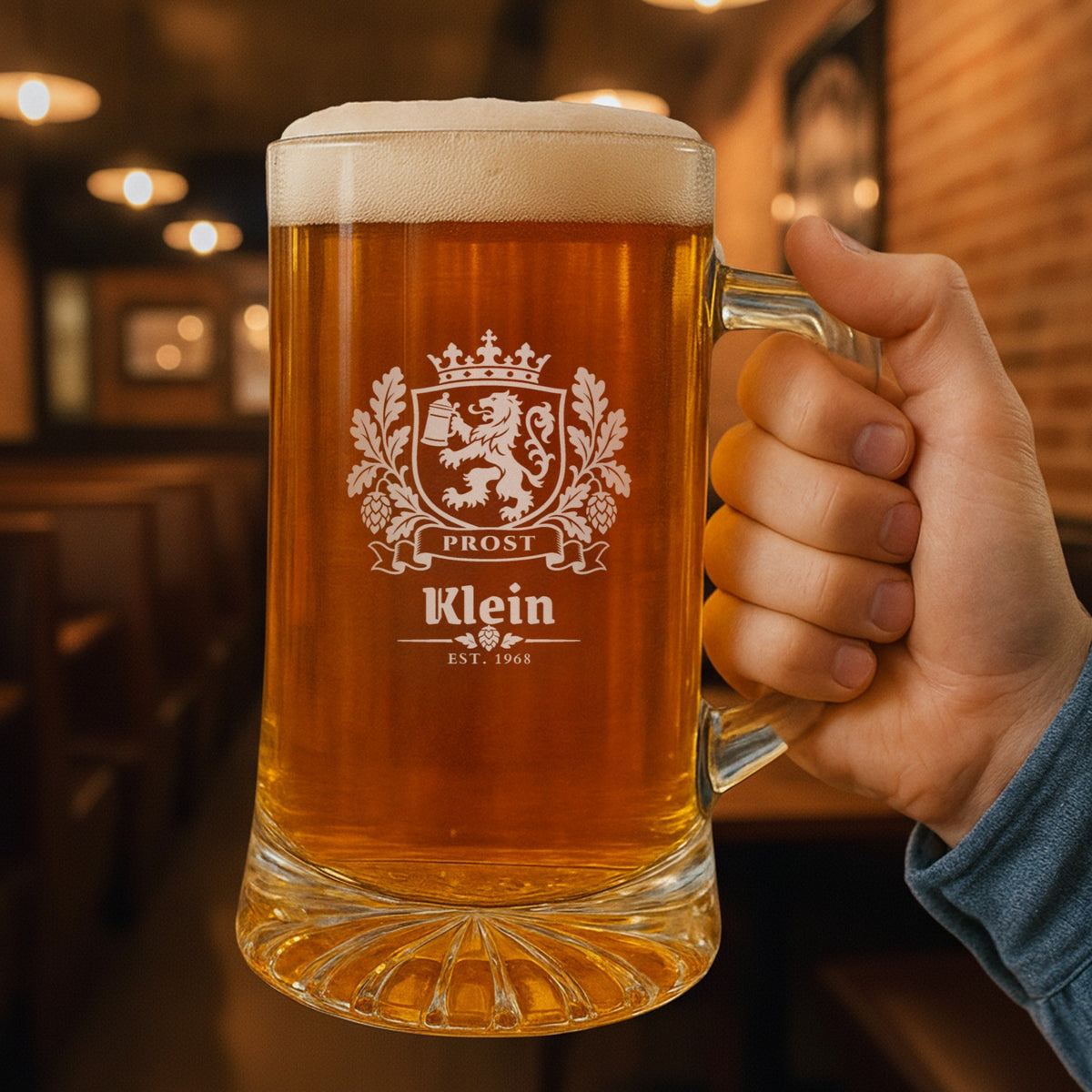 Hand holding a 25 oz Bavarian crest personalized beer stein in a pub, engraved with the lion crest, Prost, Klein and Est. 1968