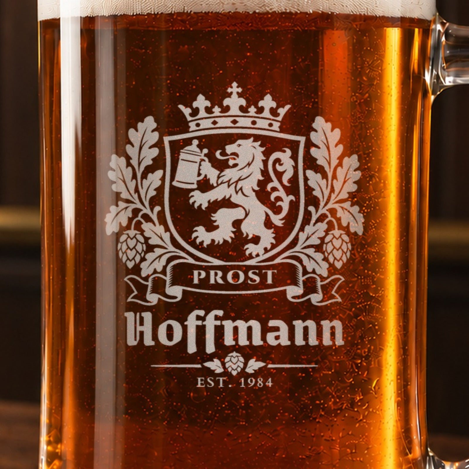 Close-up of the frosted Bavarian crest engraving: a crown, a lion holding a beer stein, oak leaves and hops, Prost, Hoffmann and Est. 1984