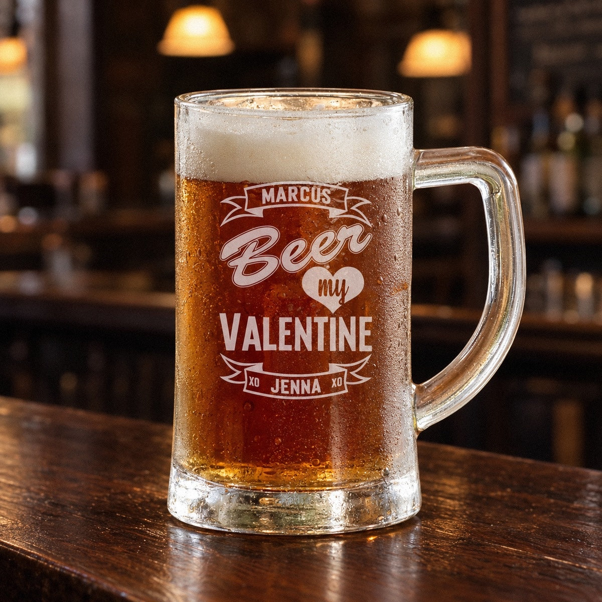 Beer My Valentine mug full of ale on a pub bar, engraved with MARCUS on the top banner and JENNA on the bottom, a guy valentine gift