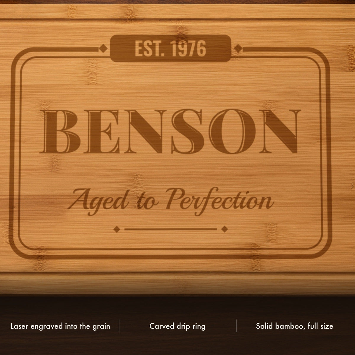Close-up of the laser engraved birthday cutting board showing the vintage name lettering and script line burned into the bamboo grain