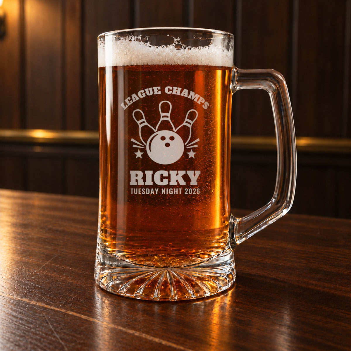 Personalized bowling beer mug on a walnut bar, engraved with a bowling ball and three pins: League Champs, Ricky, Tuesday Night 2026