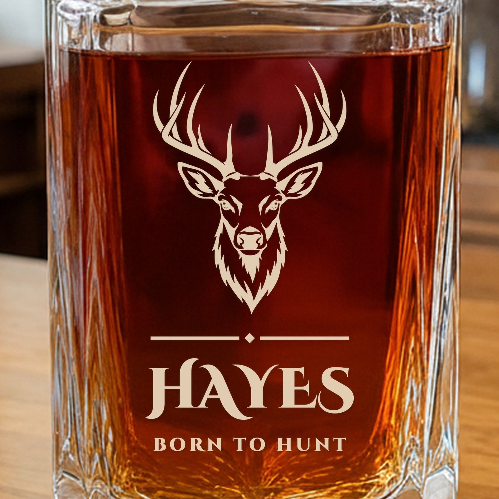 Close-up of the frosted engraving on a whiskey decanter for hunters: a whitetail buck over a fine divider, the name Hayes and Born to Hunt