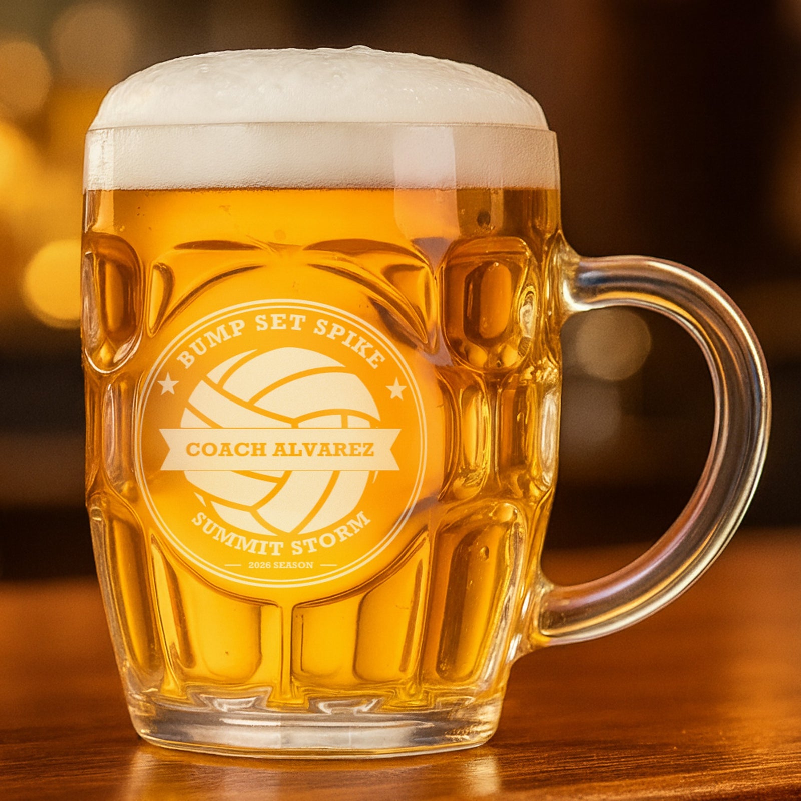 Volleyball coach beer stein filled with golden lager, engraved Bump Set Spike with Coach Alvarez across the banner and Summit Storm below the ball