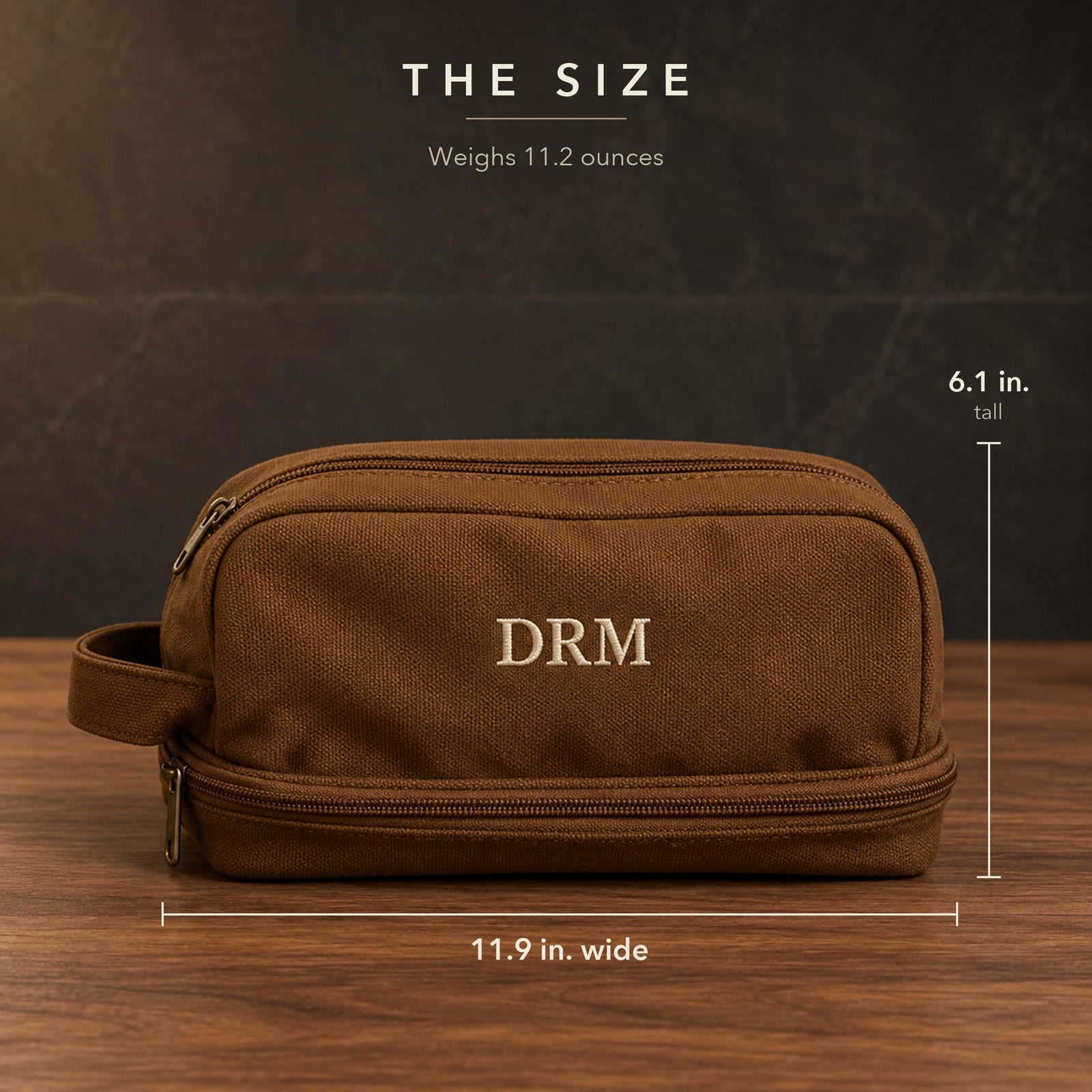 Size guide for a custom canvas toiletry bag in brown with embroidered DRM initials, measuring 11.9 inches wide and 6.1 inches tall and weighing 11.2 ounces