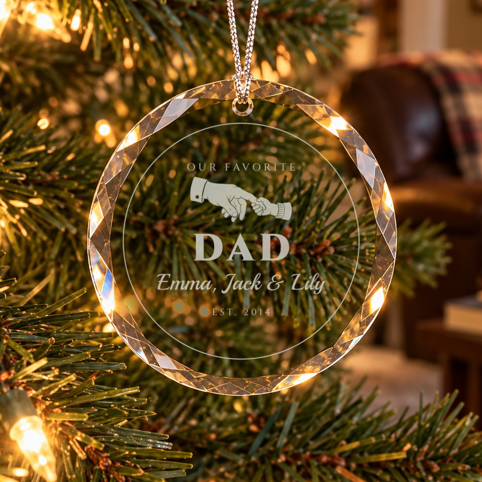 Personalized dad Christmas ornament in faceted glass on a lit tree, engraved with a big hand holding a little one, OUR FAVORITE DAD, Emma, Jack & Lily, EST. 2014