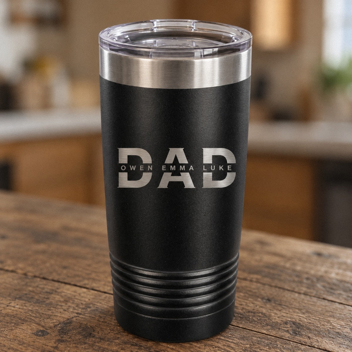 Black dad tumbler engraved with a big DAD and the kids' names OWEN, EMMA and LUKE across the middle, a personalized fathers day tumbler