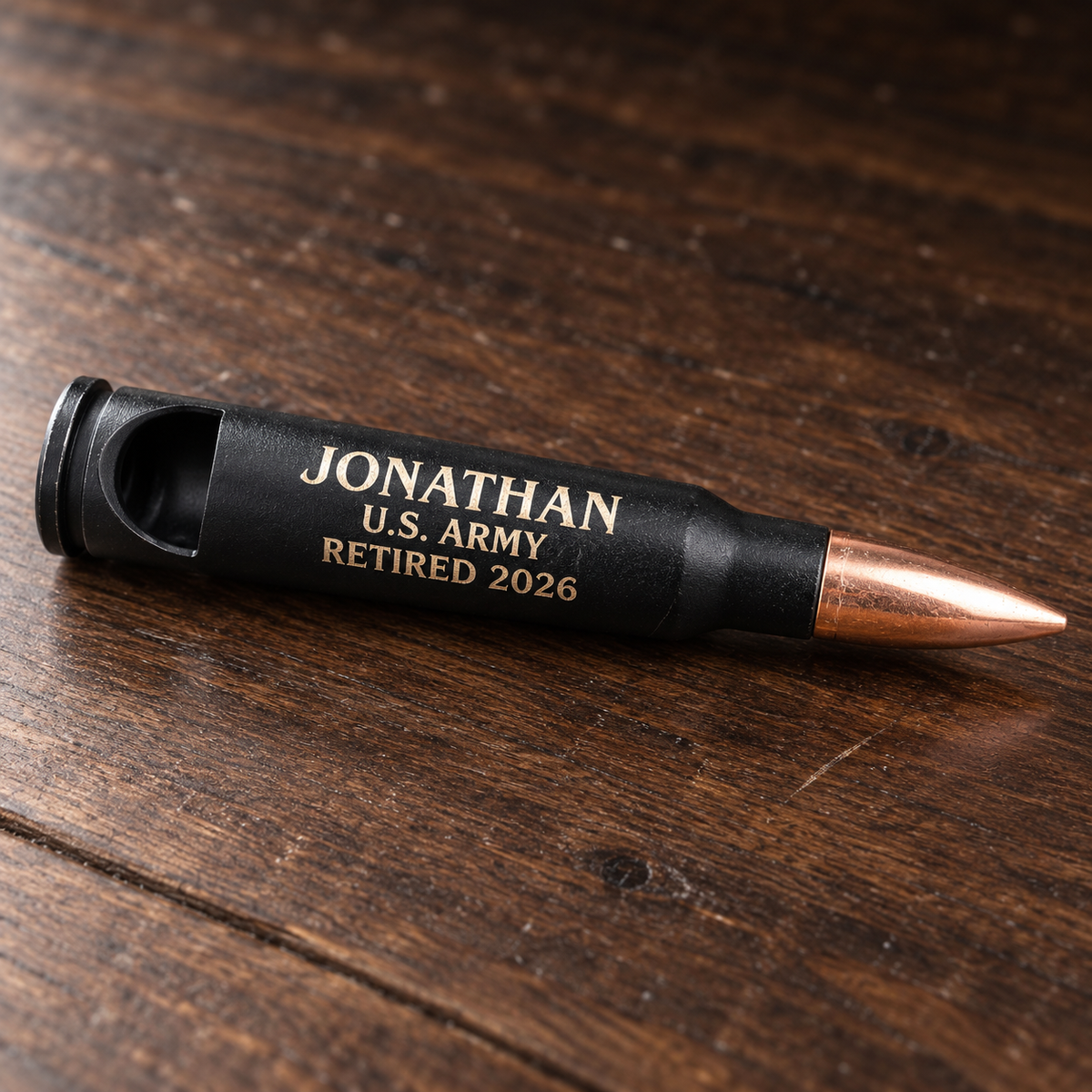 Engraved 50 cal bullet bottle opener in matte black with a copper tip, laser engraved Jonathan, U.S. Army, Retired 2026 on a bar top