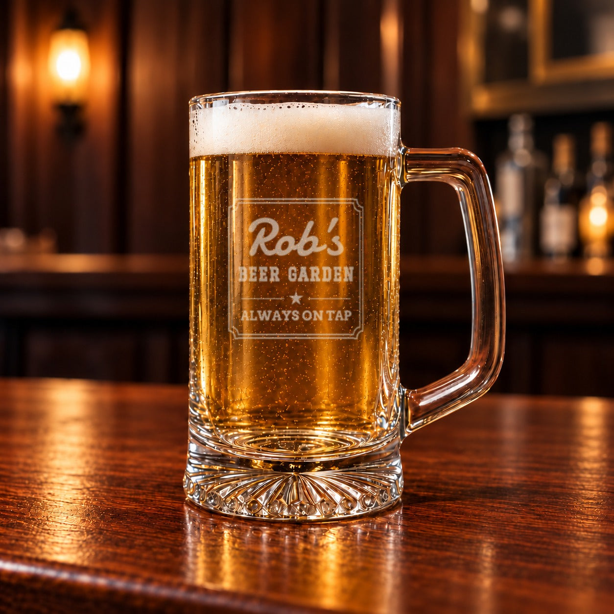 Close-up of a frosted etched glass beer mug full of lager reading Rob's Beer Garden Always On Tap inside a notched double-line frame with a star