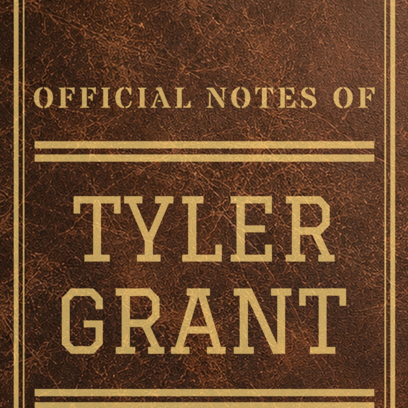 Close-up of the gold laser engraving on the brown college journal: Official Notes Of Tyler Grant in big varsity letters between athletic stripes
