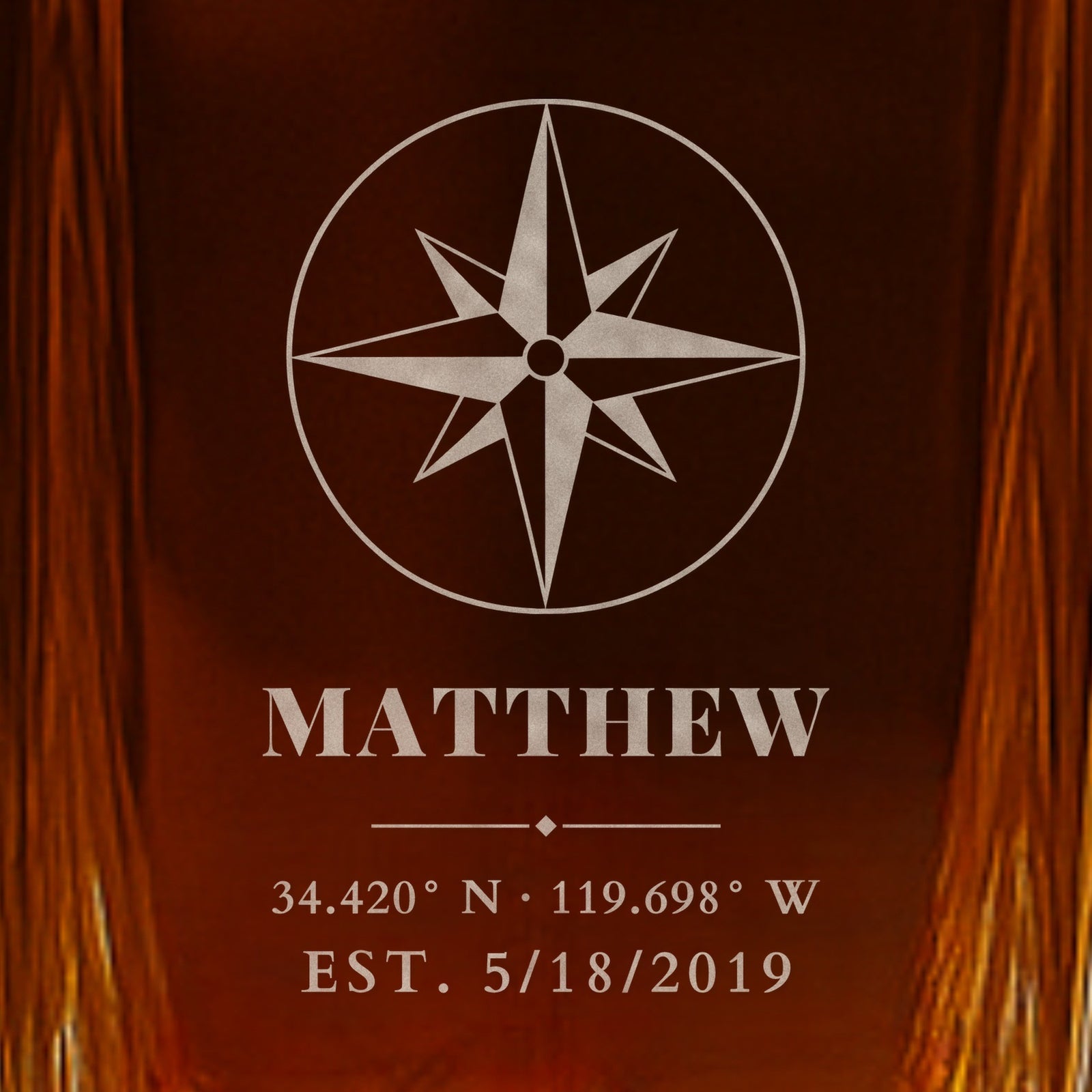 Close-up of frosted engraving on a whiskey decanter for husband: a compass rose, the name Matthew, Santa Barbara wedding coordinates and EST. 5/18/2019