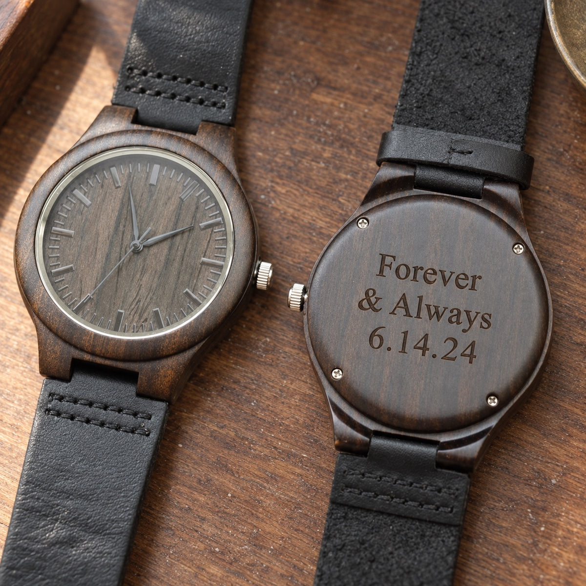 Engraved wooden watch for men in dark sandalwood with a black leather band, shown face up beside its back engraved Forever & Always 6.14.24