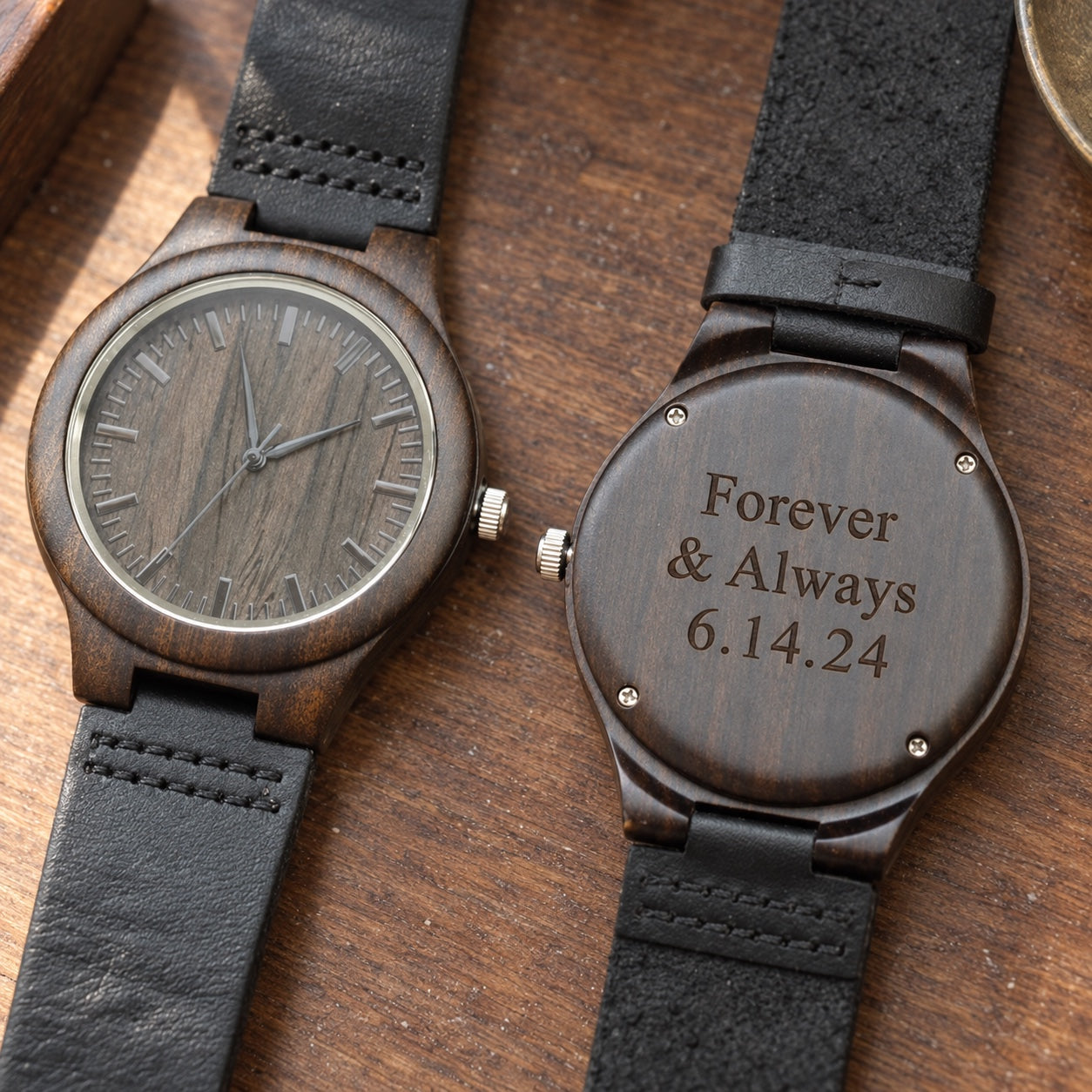 Engraved wooden watch for men in dark sandalwood with a black leather band, shown face up beside its back engraved Forever & Always 6.14.24