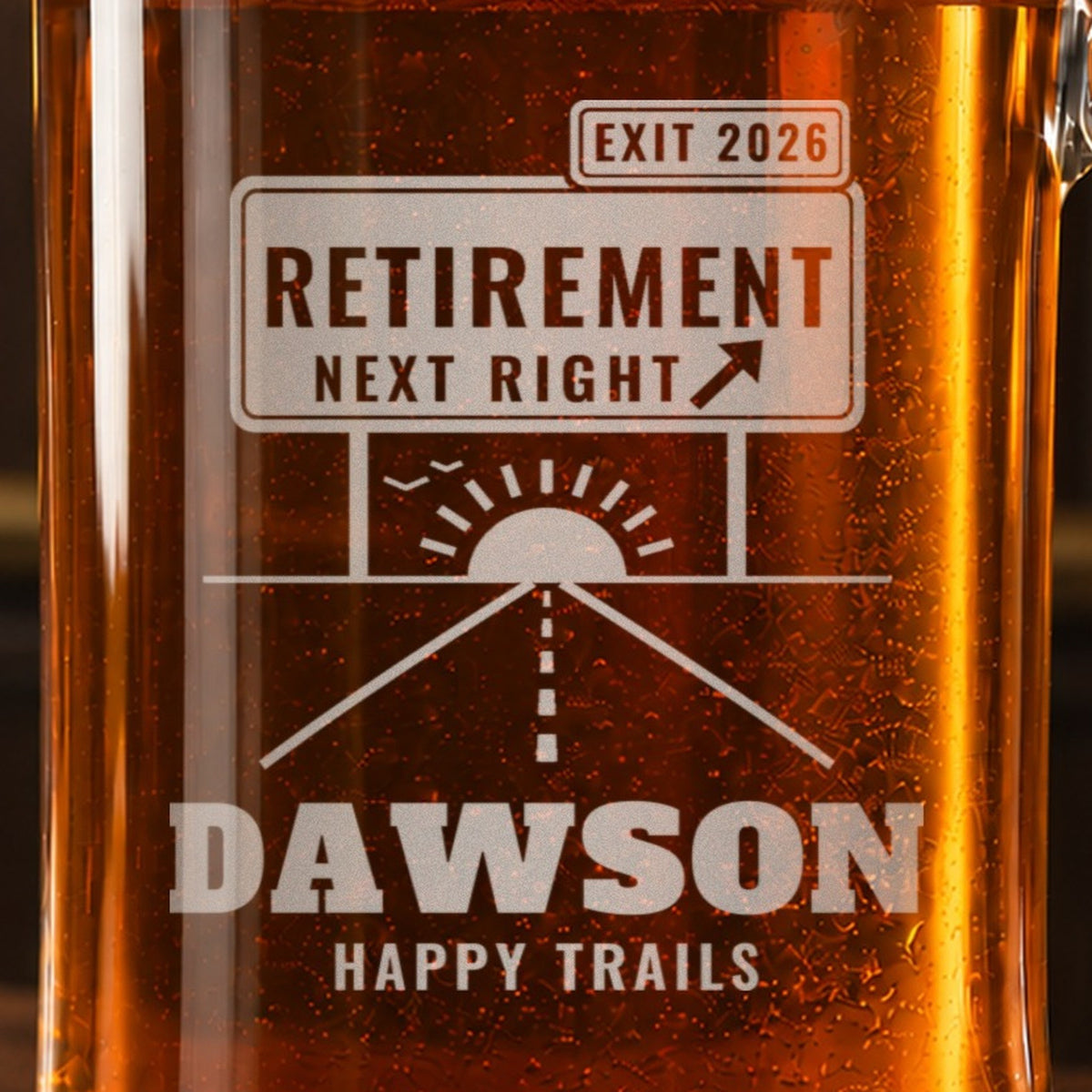 Close-up of the frosted RETIREMENT NEXT RIGHT exit sign engraving with the road and sunrise below, reading EXIT 2026, DAWSON and HAPPY TRAILS