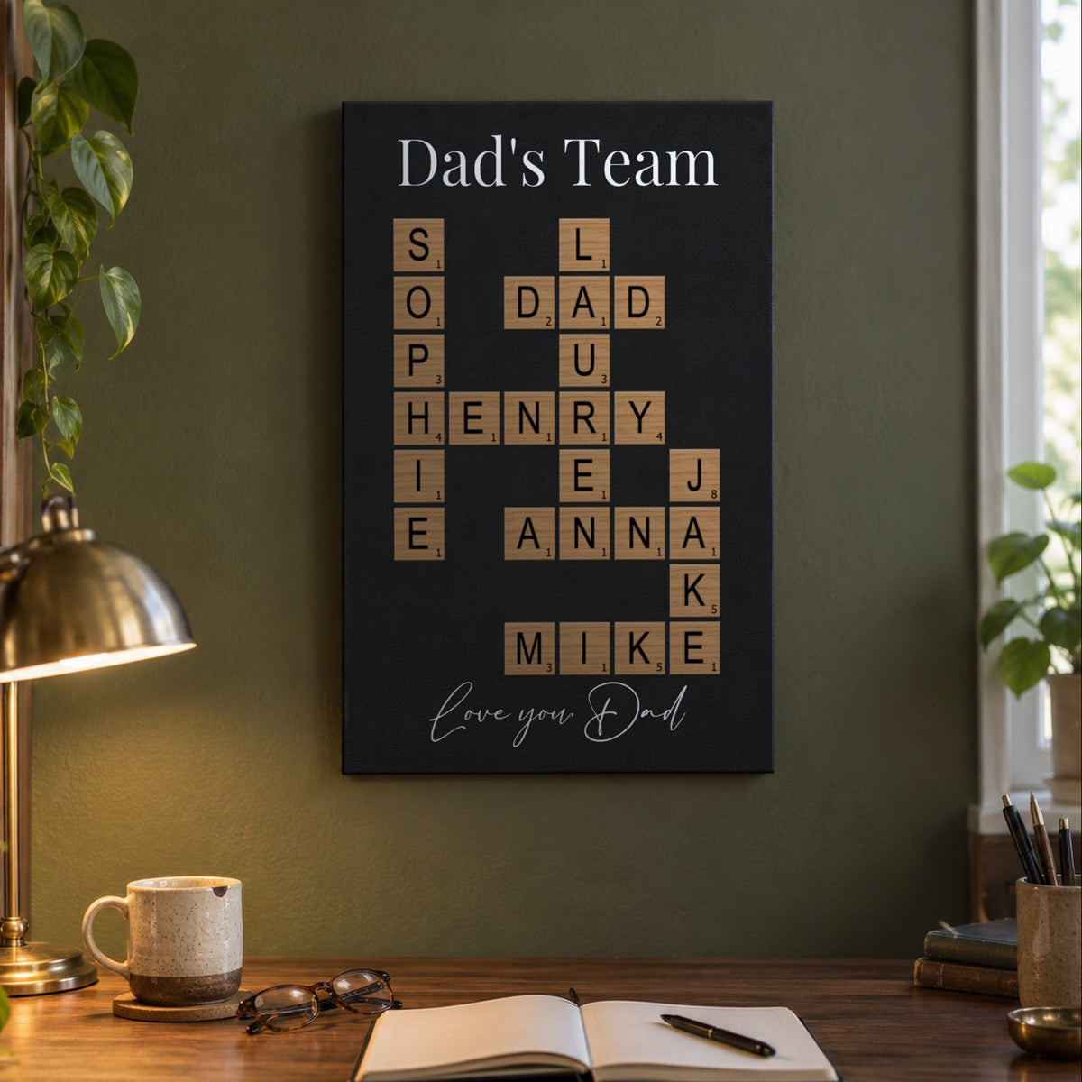 Dad's Team family crossword art above a home office desk, a crossword puzzle of family names including Dad, Sophie, Henry, Lauren and Anna