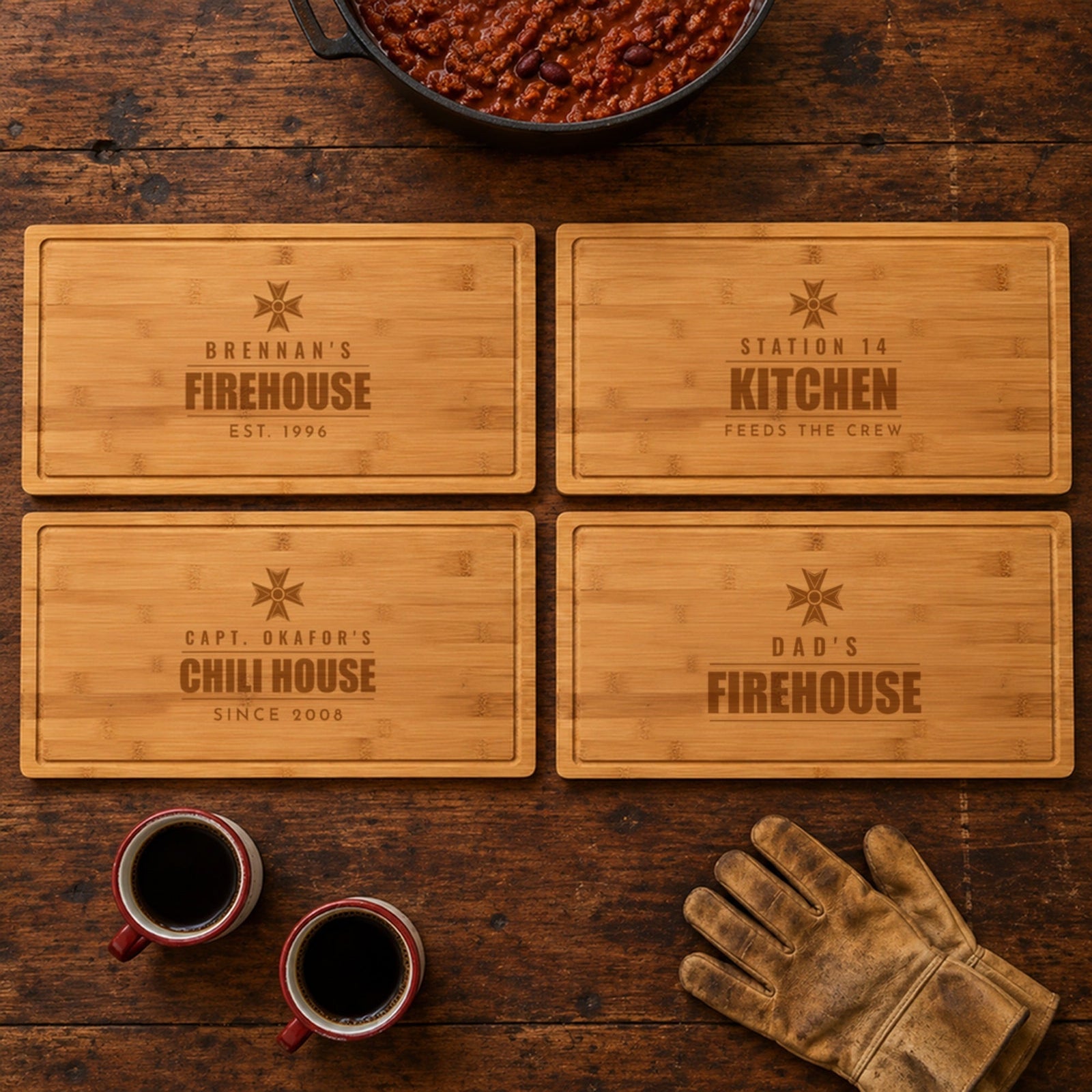 Four engraved firefighter cutting boards on a firehouse table: Brennan's Firehouse, Station 14 Kitchen, Capt. Okafor's Chili House and Dad's Firehouse