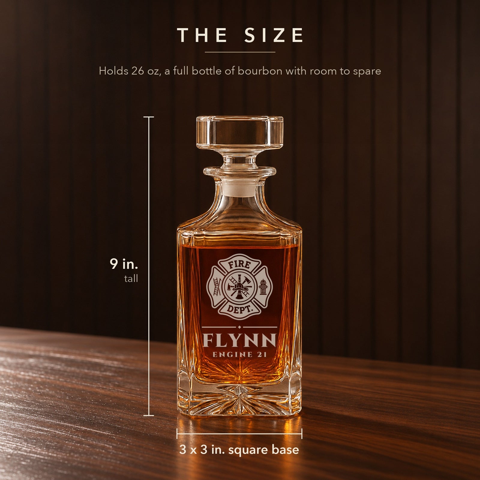 Size of the engraved firefighter decanter: 9 inches tall with a 3 by 3 inch square base, holds 26 oz, engraved Flynn, Engine 21 under the cross